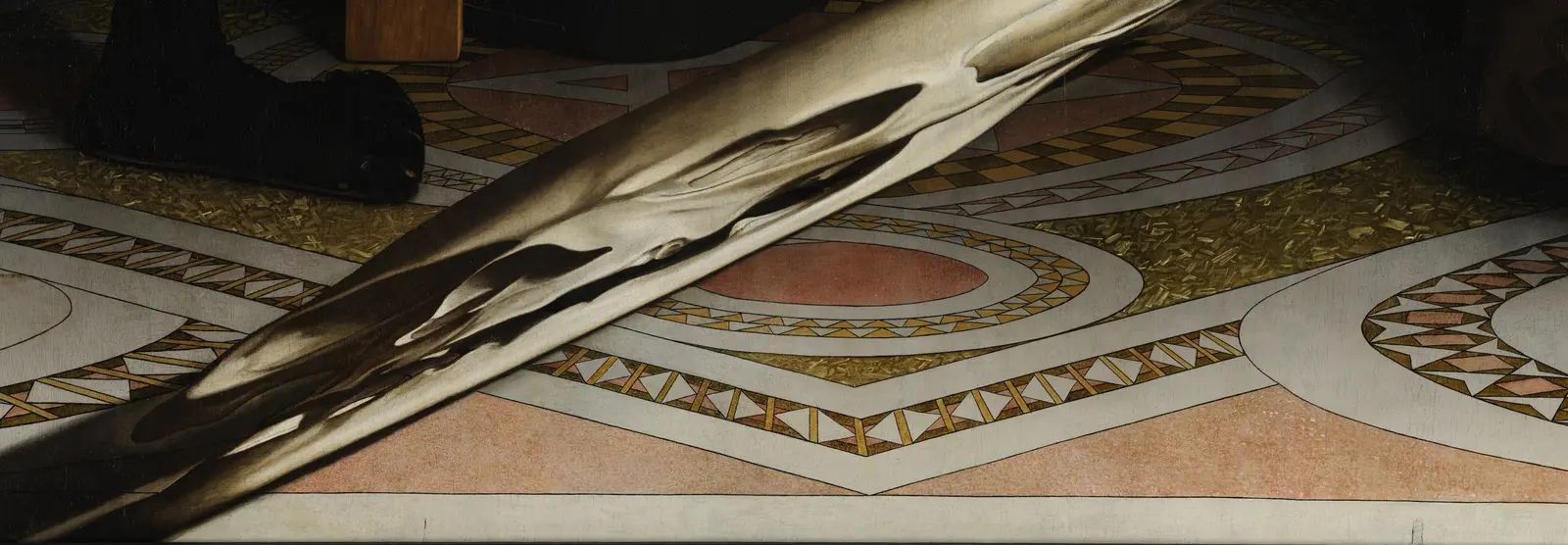 The bottom corner of the floor's large diamond, with two banded sides rising from it, the right one into a circular border and the left one passing under the pale skull.